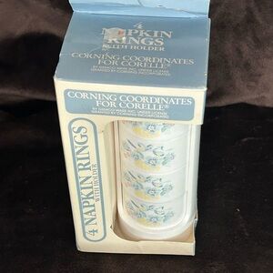 Corelle 4 Napkins Rings w/Holder in original box. Blue flowers in yellow basket